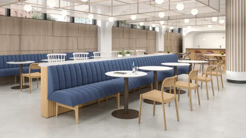 Office cafe rendering with blue channel-tufted banquettes, oak side chairs and round tables, Anomatics